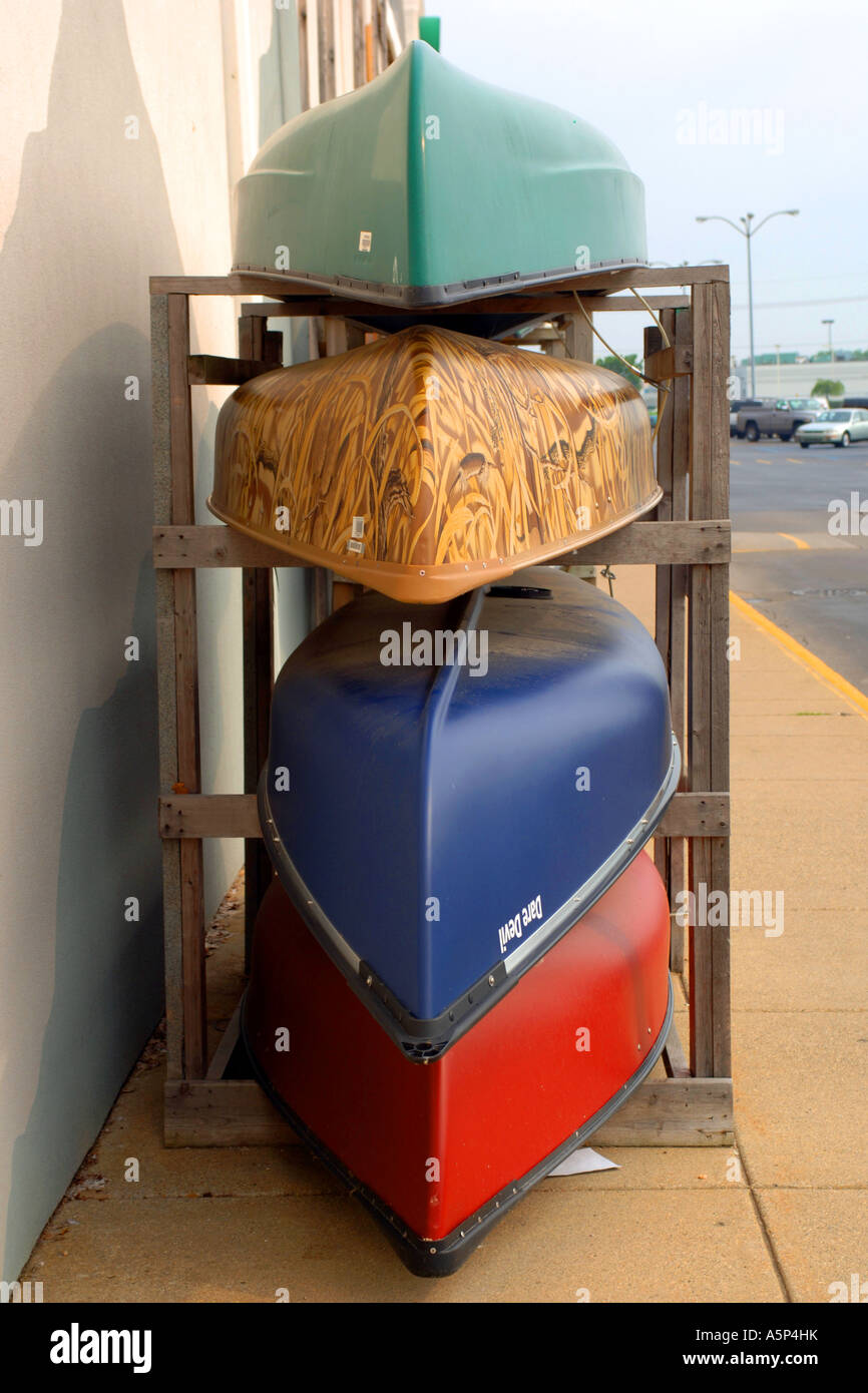 Stacked Canoes in various colors outside a retail store in Triadelphia