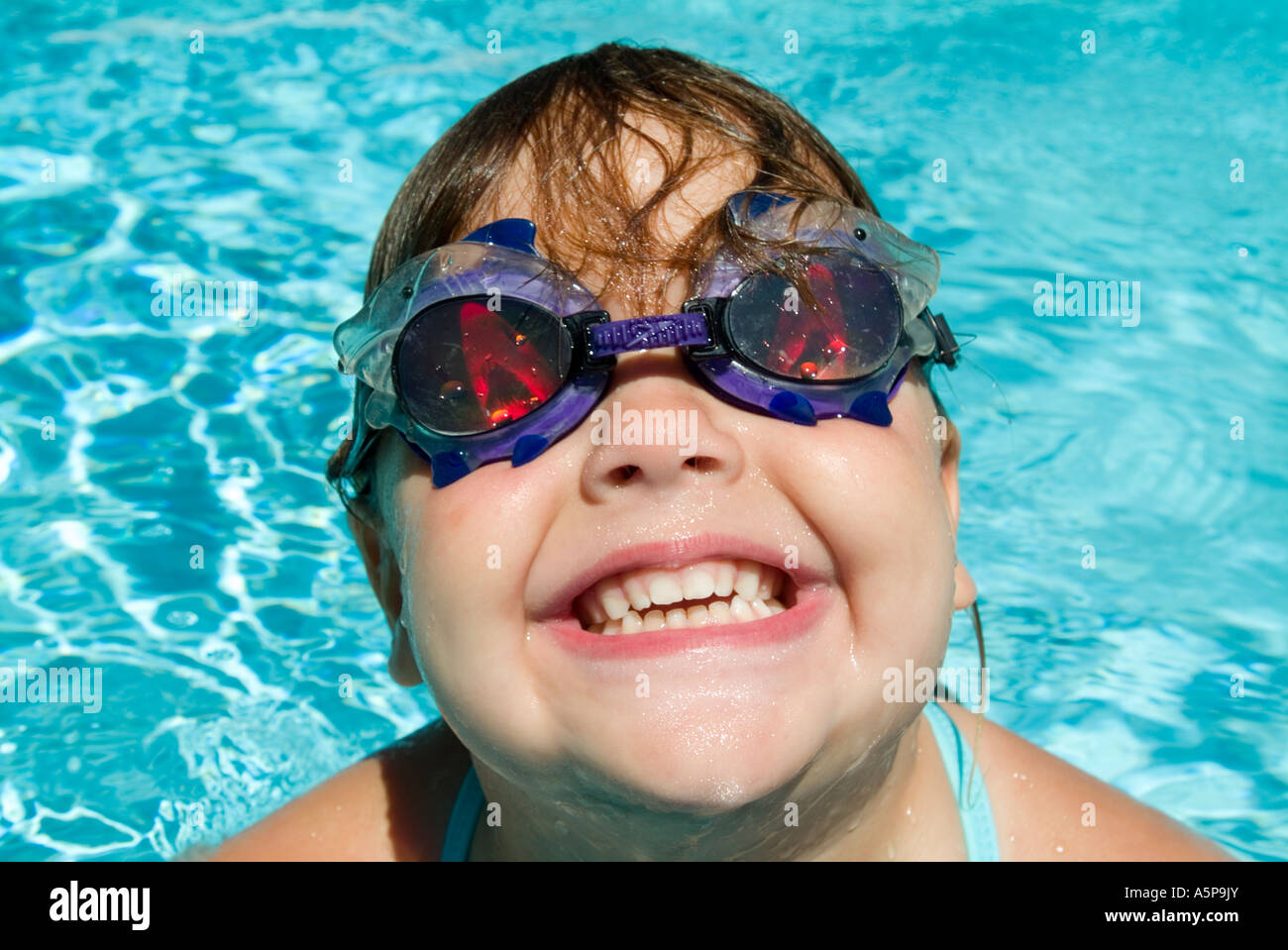 Girl laughing and playing in swimming pool. Stock Photo