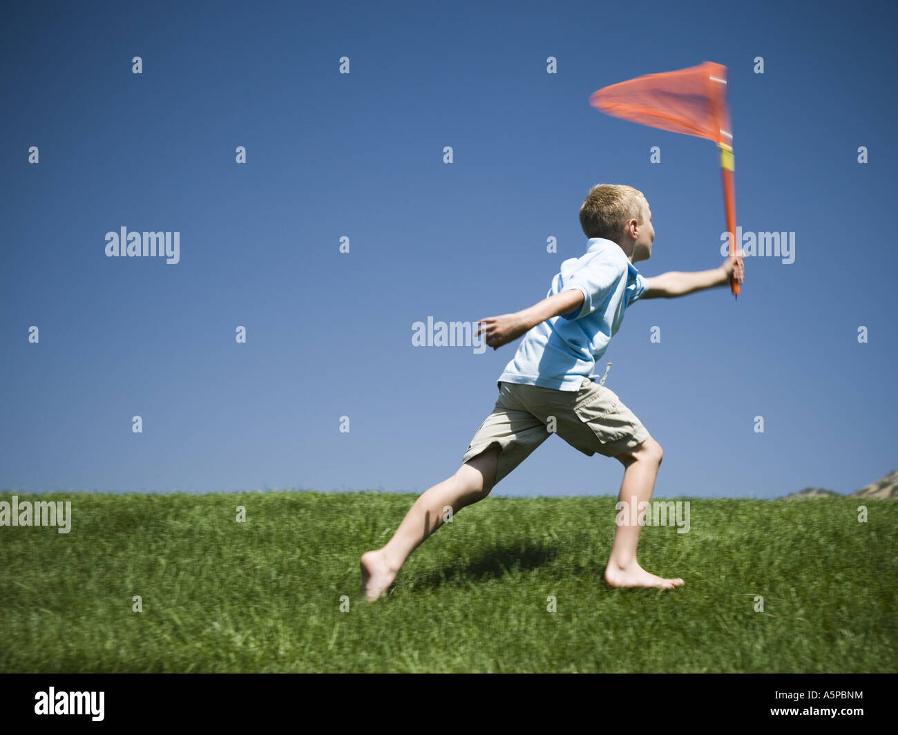 Boy playing on a hill Stock Photo