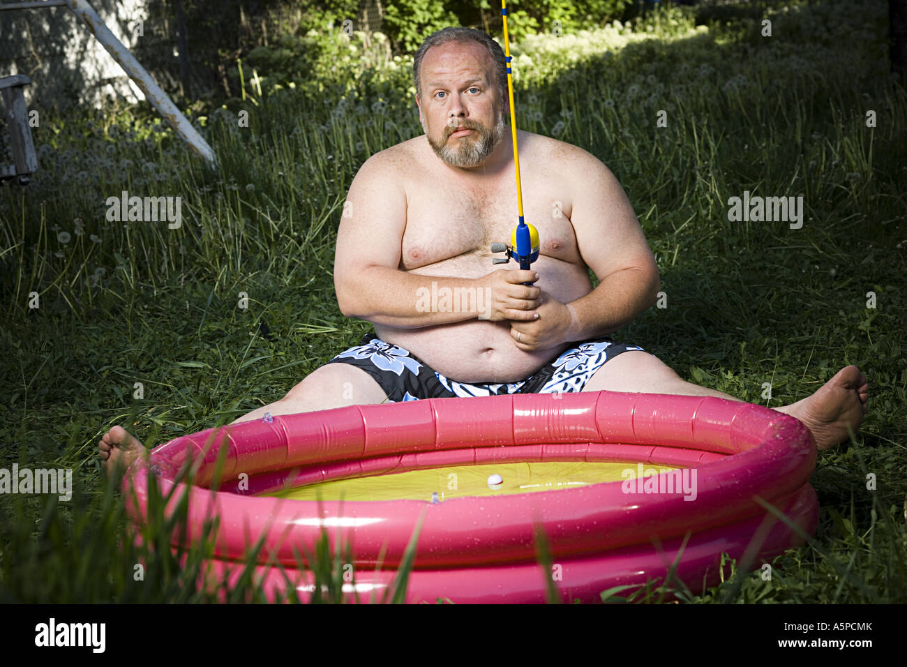 Overweight man in inflatable wading pool Stock Photo Alamy