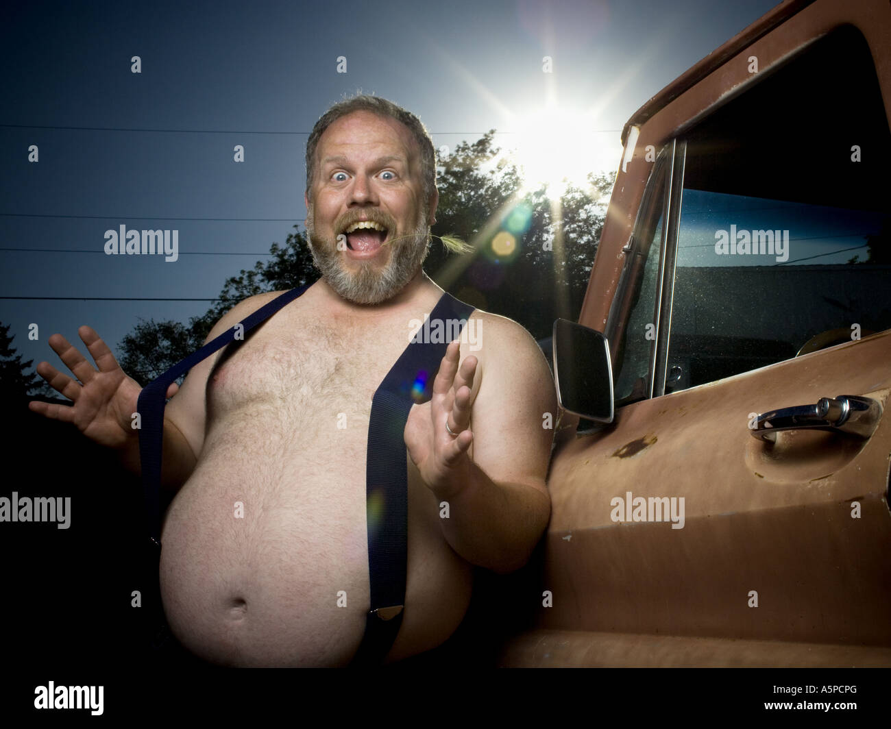 Overweight man with suspenders by truck Stock Photo