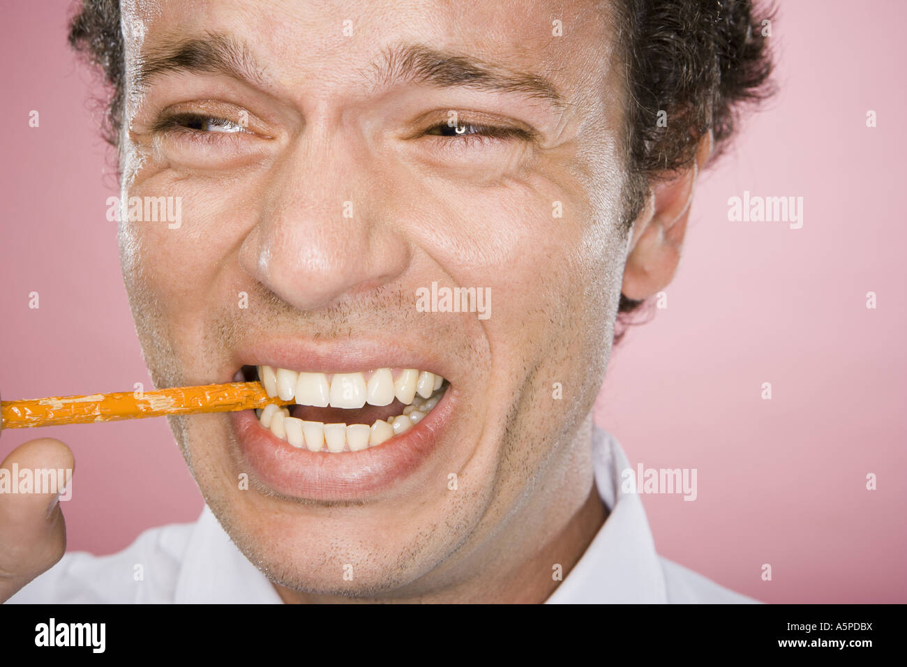 Close-up of a man biting the end of a pencil Stock Photo