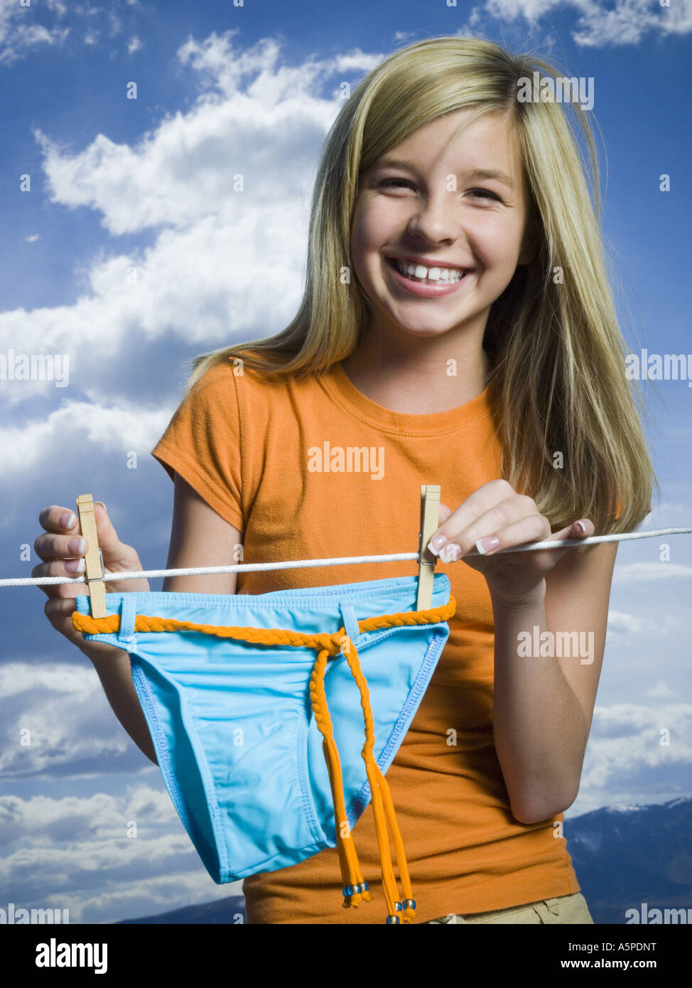 Portrait of a teenage girl drying a bikini bottom on a clothesline Stock  Photo - Alamy