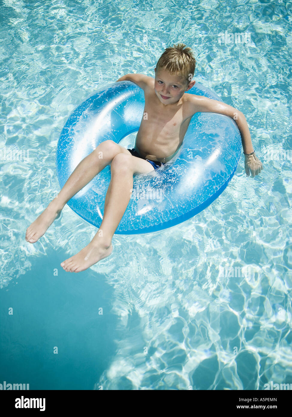 Young boy floating on life ring in swimming pool Stock Photo - Alamy