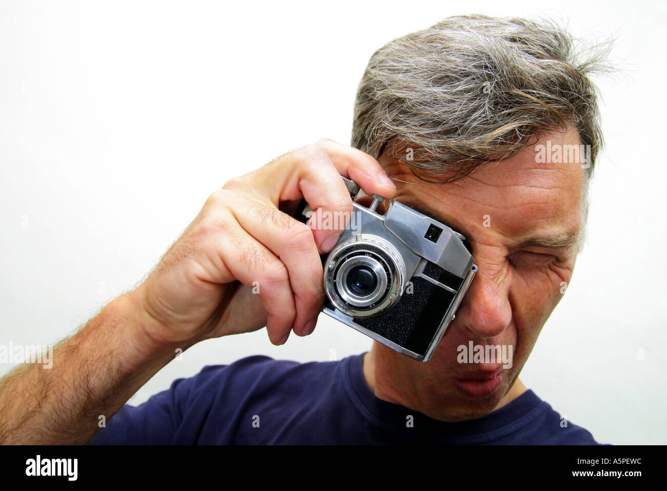 nerdy looking man taking a photograph with old fashioned camera Stock Photo