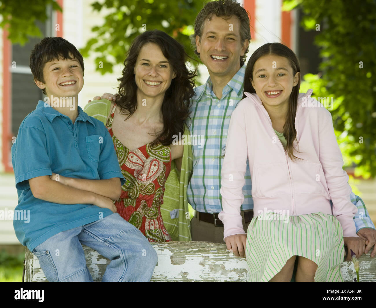 Portrait of a man and a mid adult woman smiling with their children ...