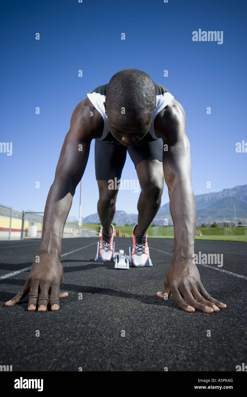 Track runner in starting position ready to race Stock Photo Alamy