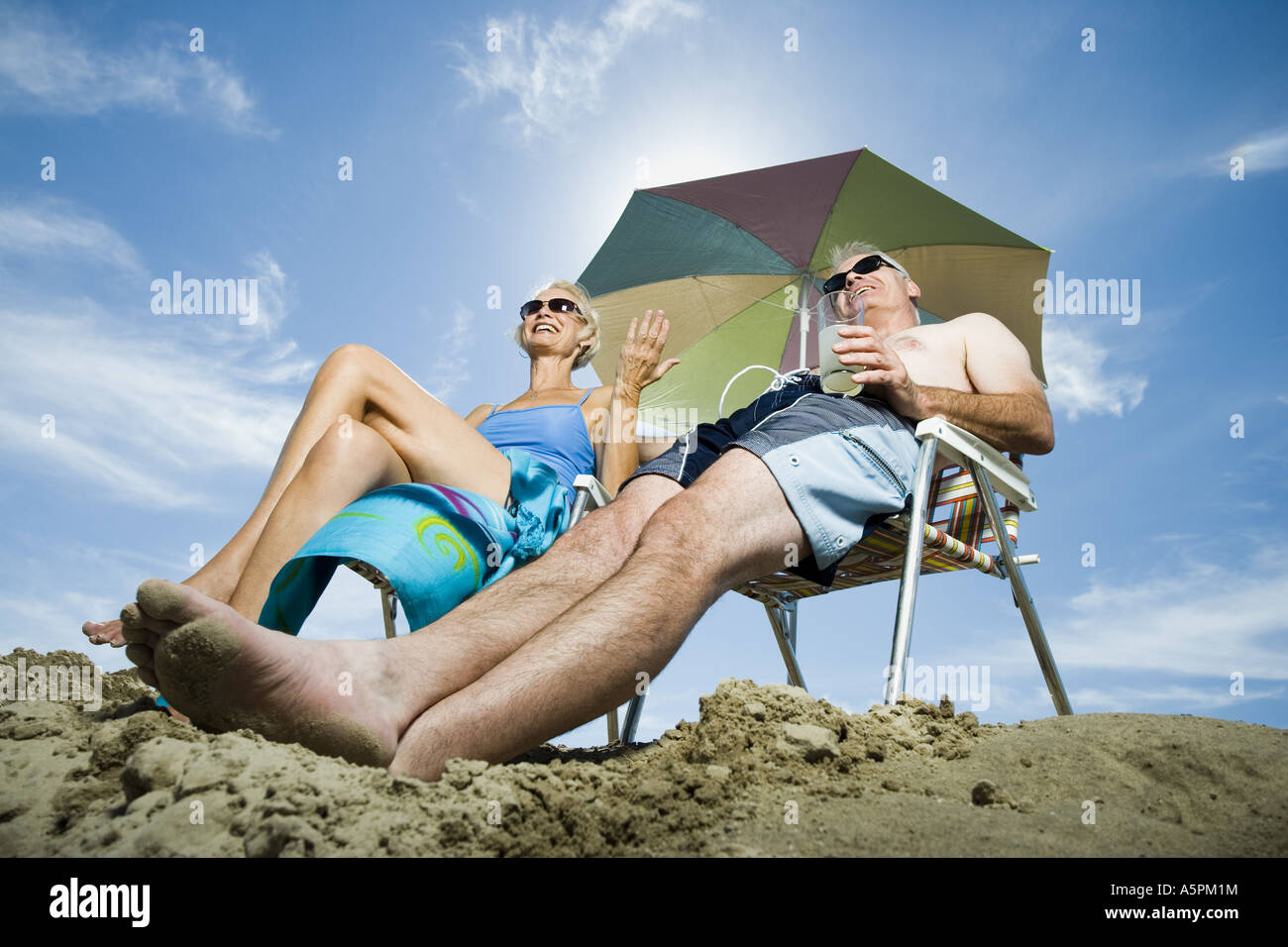 Mature couple at the beach relaxing on deck chairs Stock Photo - Alamy