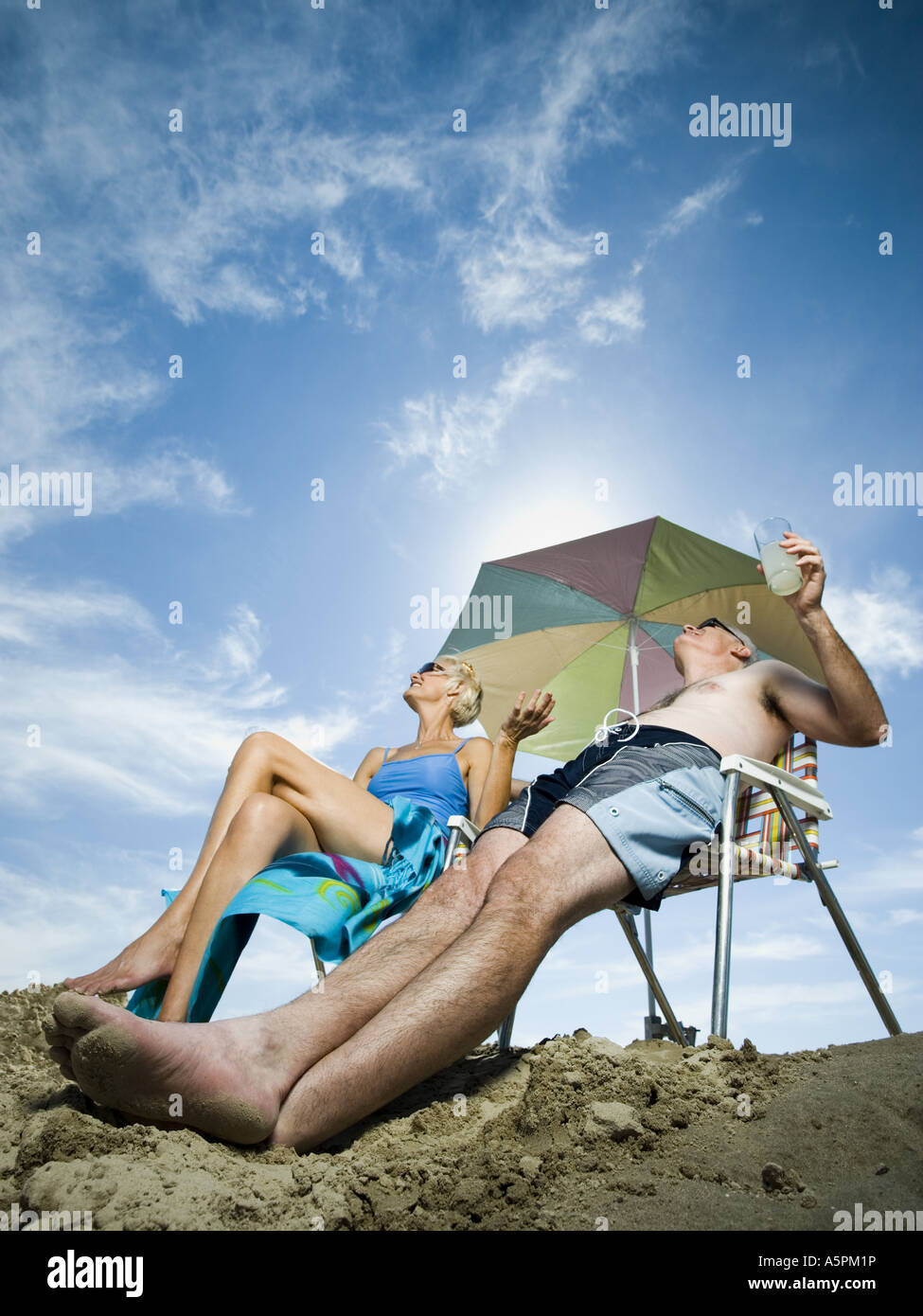 Mature couple at the beach relaxing on deck chairs Stock Photo - Alamy