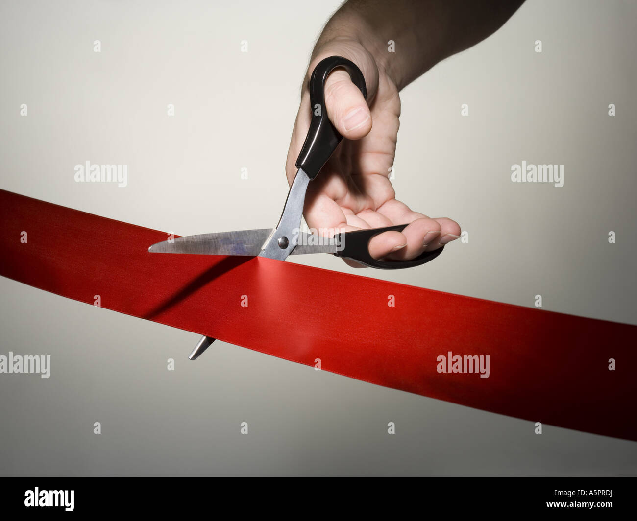 Hand cutting a red ribbon with scissors Stock Photo Alamy
