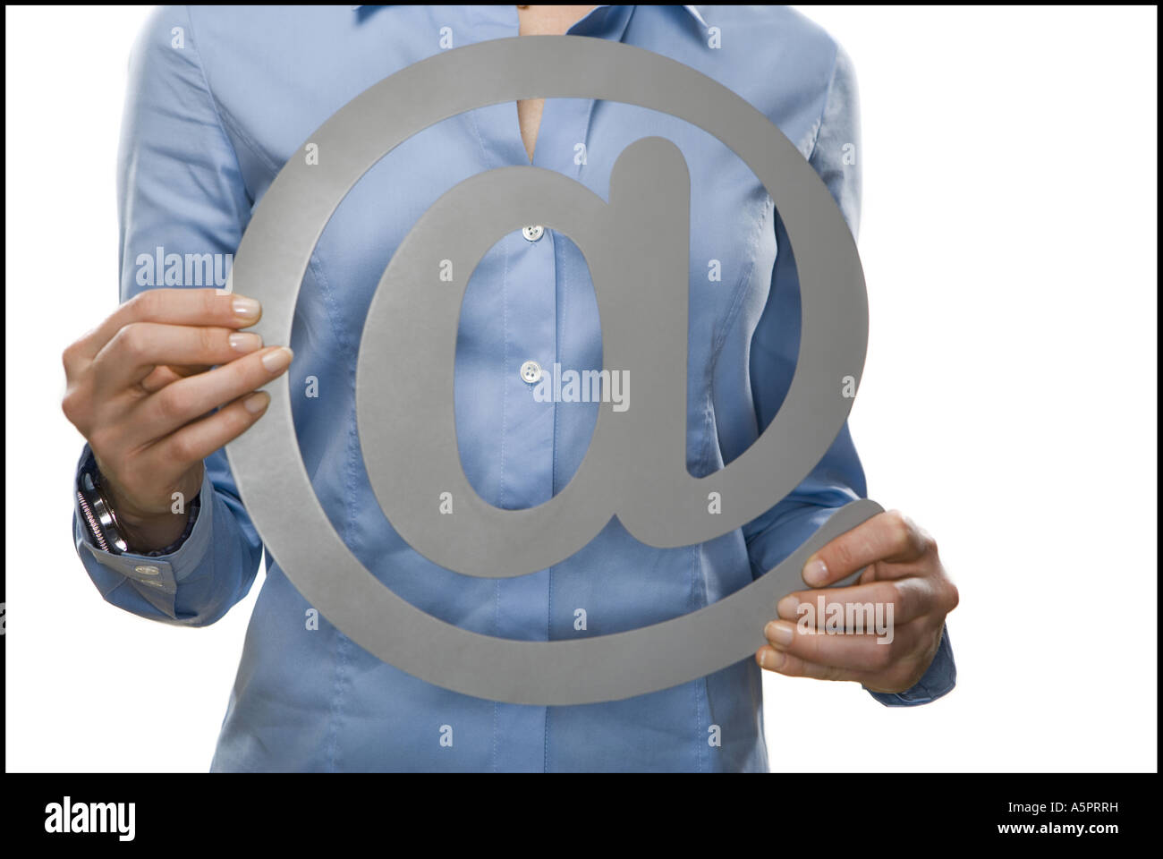 Mid section view of a mid adult woman holding an 'at' symbol Stock Photo