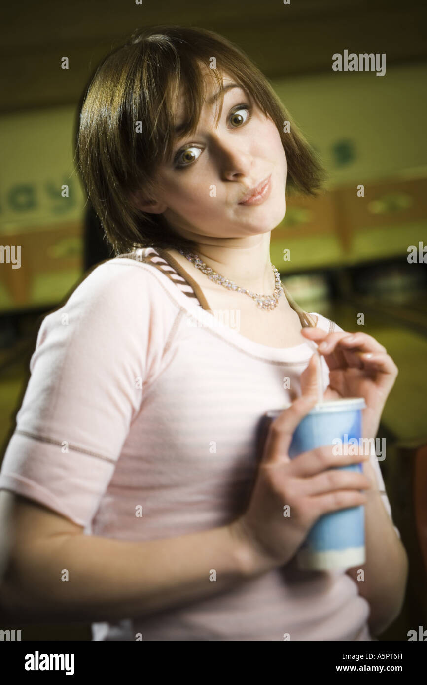 Portrait of a teenage girl holding a disposable glass of cola and smiling Stock Photo
