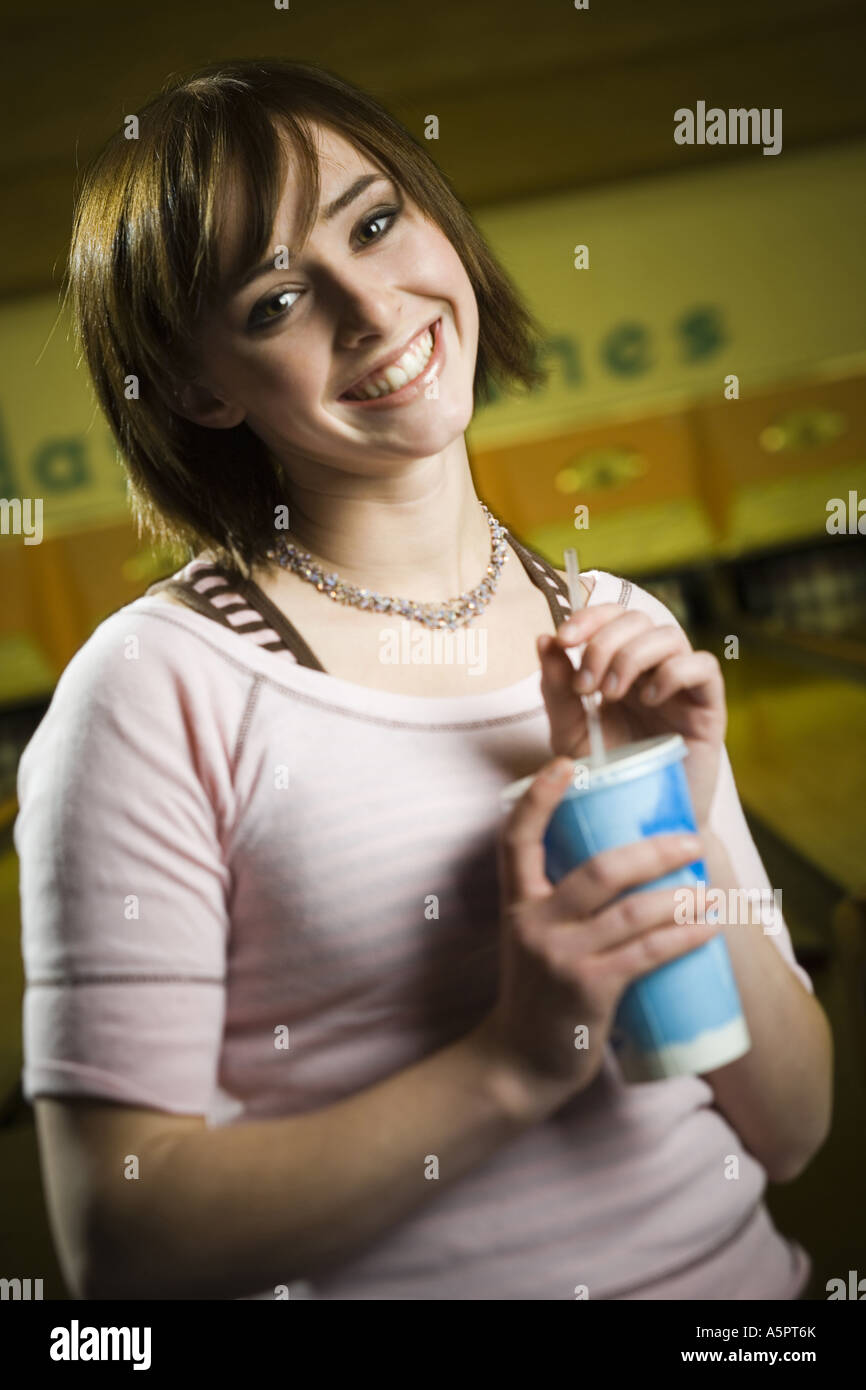 Portrait of a teenage girl holding a disposable glass of cola and smiling Stock Photo