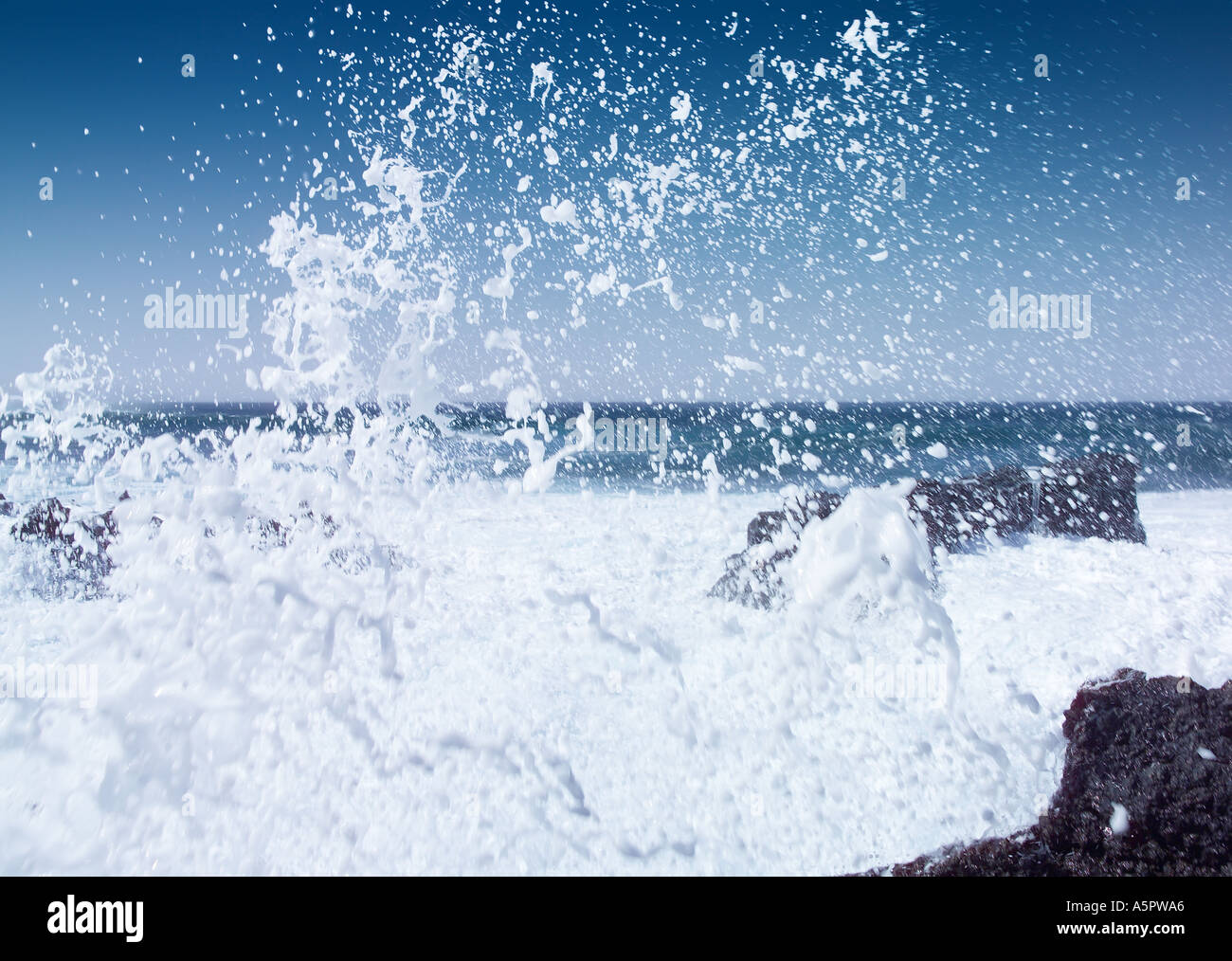 Black basalt volcanic beach and rough blue sea with white crested waves