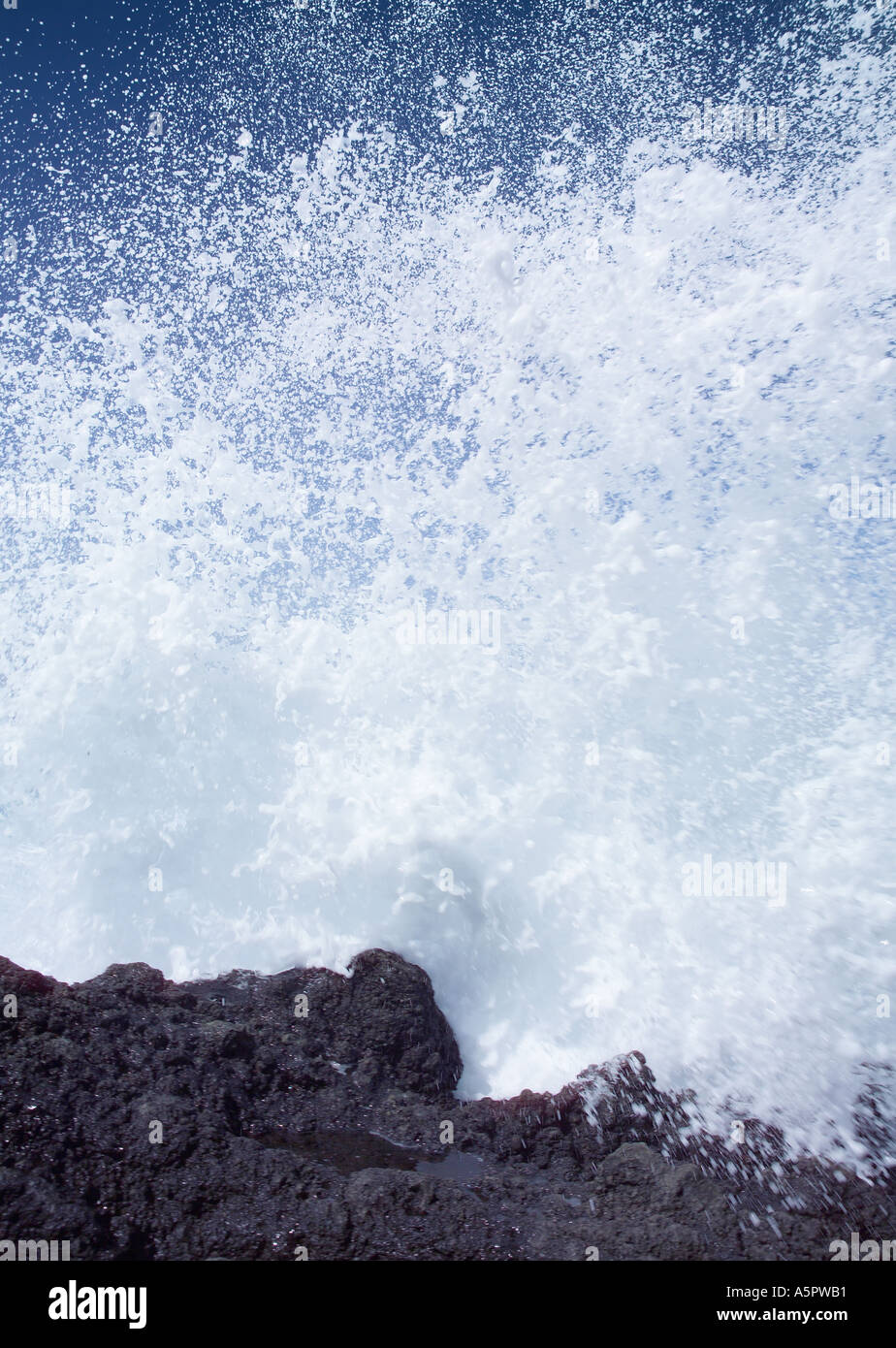 Black basalt volcanic beach and rough blue sea with white crested waves