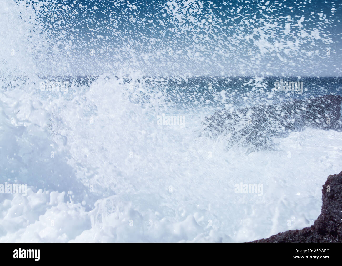 Black basalt volcanic beach and rough blue sea with white crested waves