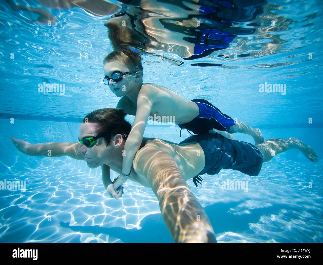 Father and son swimming underwater in pool Stock Photo Alamy