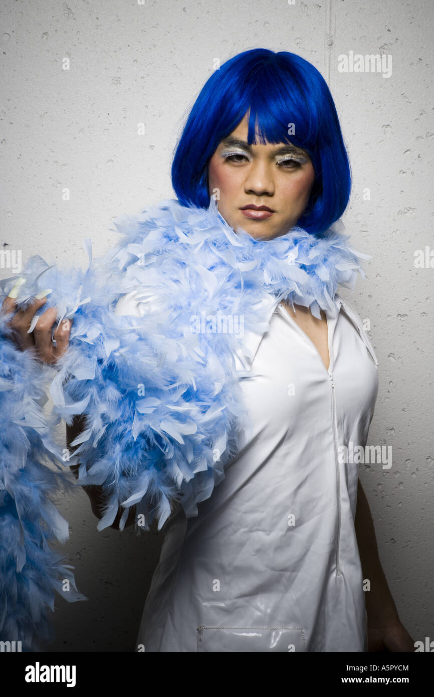 Man in blue wig and feather boa flirting Stock Photo Alamy