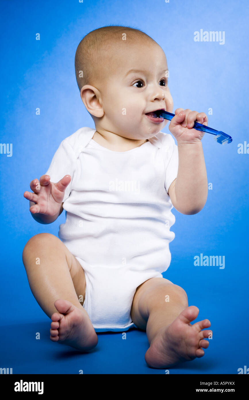 Baby chewing on toothbrush Stock Photo Alamy
