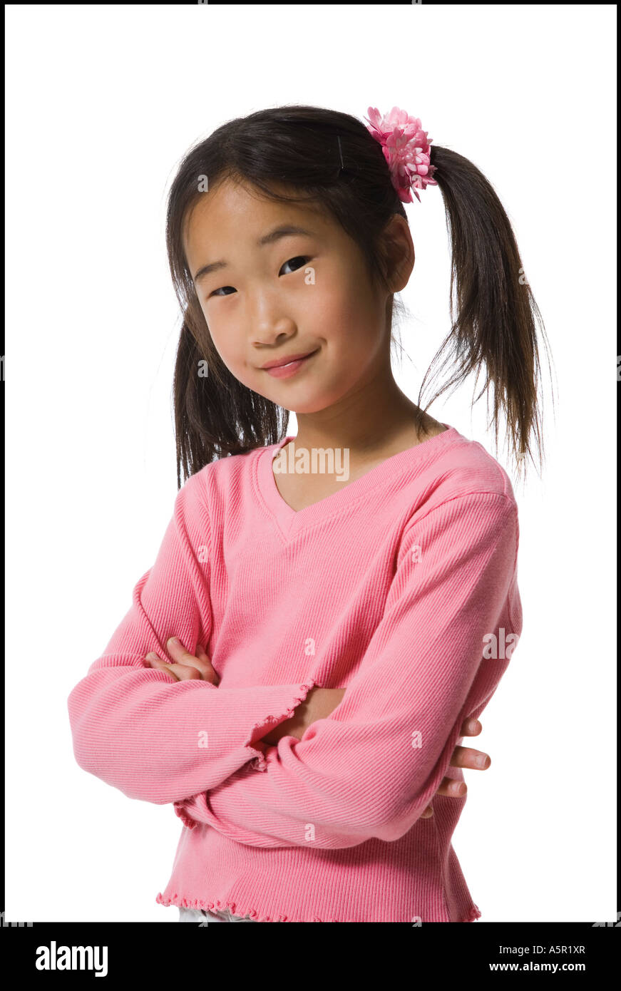 Portrait of a girl standing with her arms folded and smiling Stock Photo