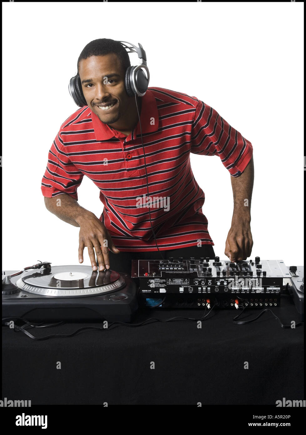 DJ with headphones spinning records Stock Photo - Alamy