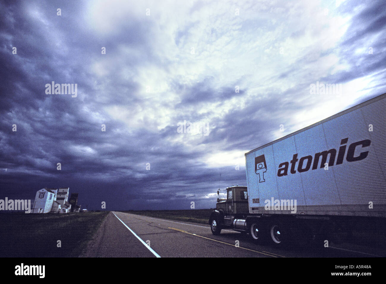 Canada Prairies Saskatchewan Zealandia grain elevators and prairie road with Atomic truck beneath big dramatic sky JMH0243 Stock Photo