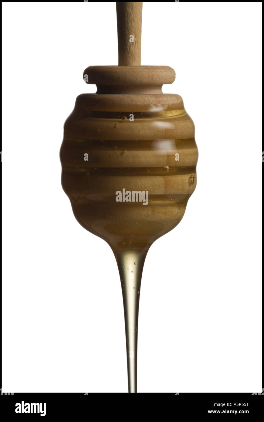 Drop of honey falling from a honey dipper Stock Photo - Alamy