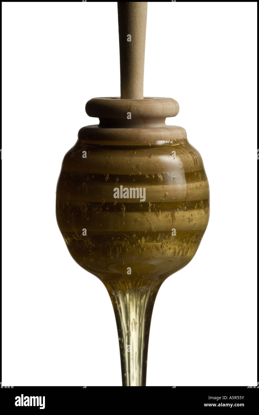 Drop of honey falling from a honey dipper Stock Photo - Alamy