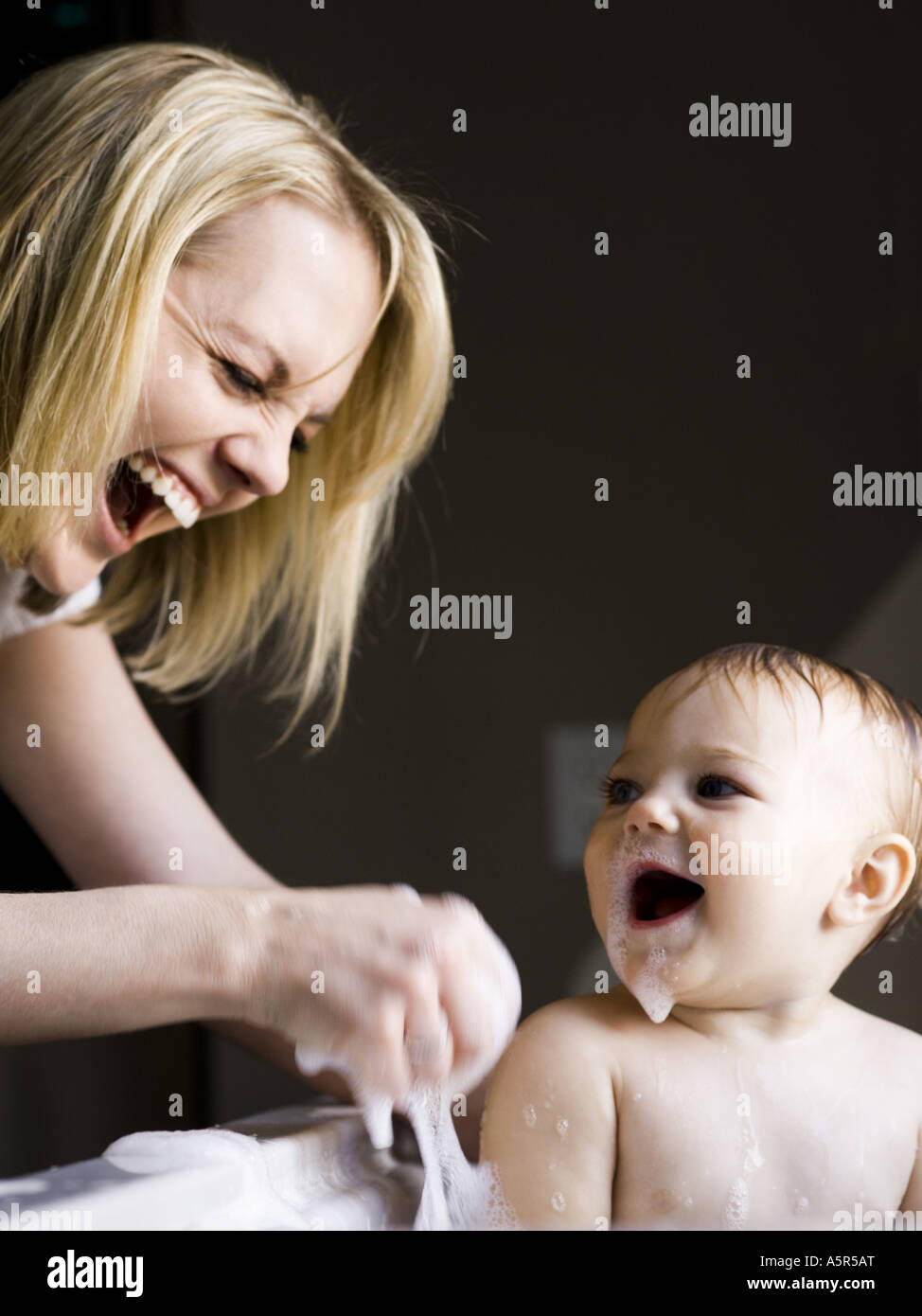 Woman bathing baby in sink Stock Photo Alamy