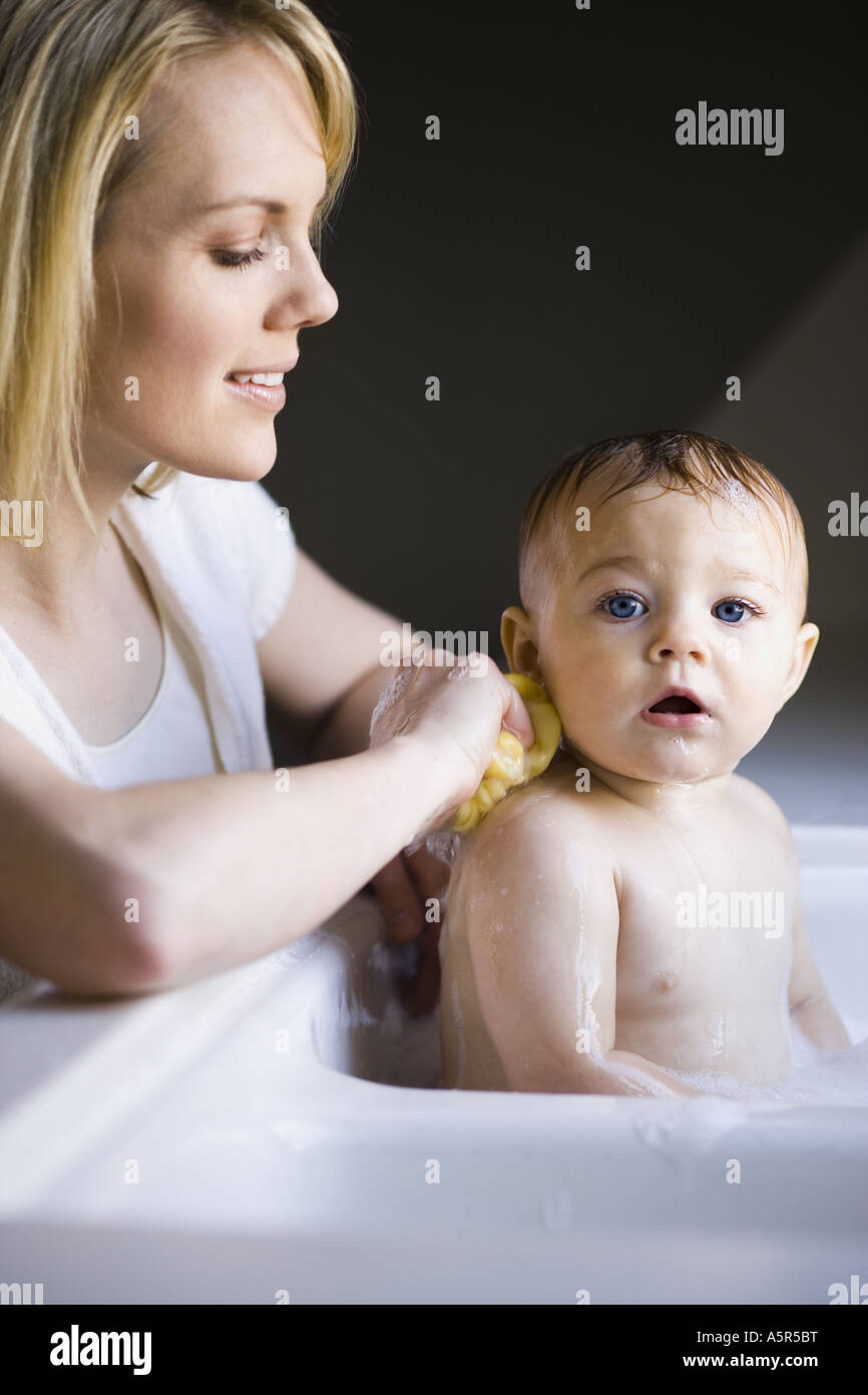 Woman bathing baby in sink Stock Photo Alamy