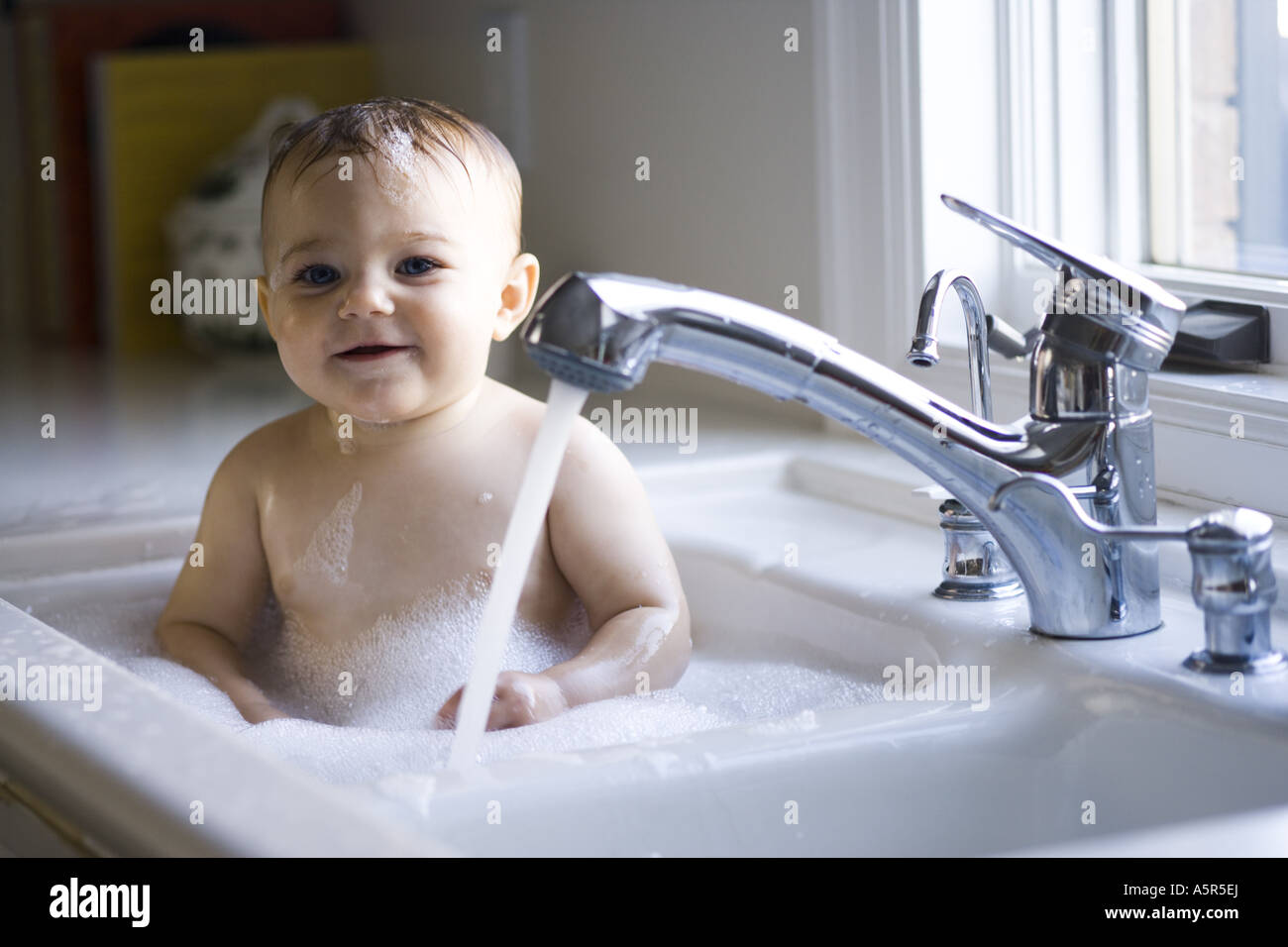 Baby bathing in sink Stock Photo Alamy