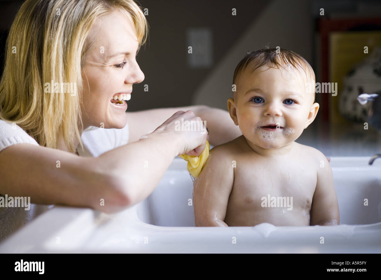 Woman bathing baby in sink Stock Photo - Alamy