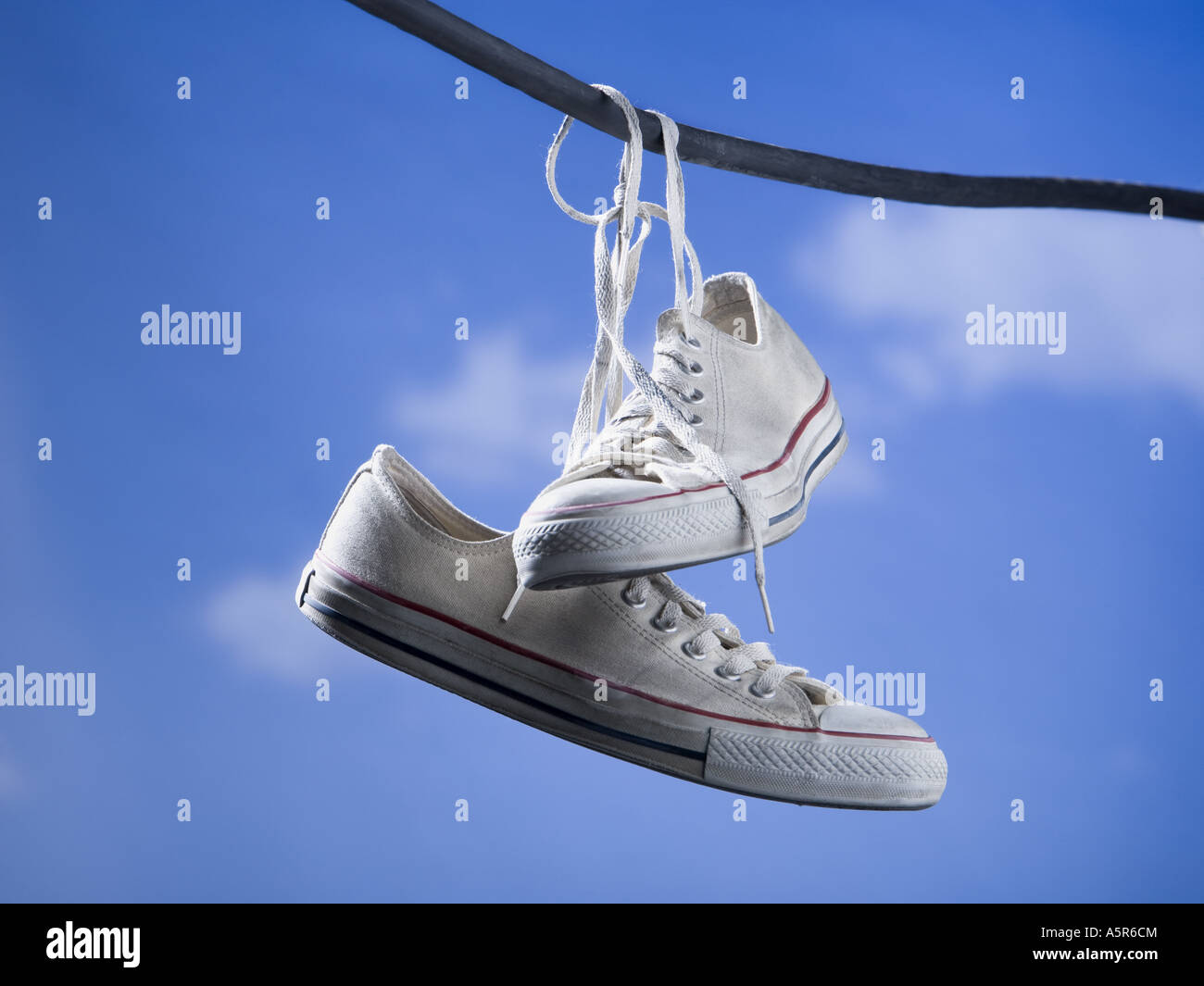 Running shoes hanging on wire outdoors with blue sky Stock Photo - Alamy