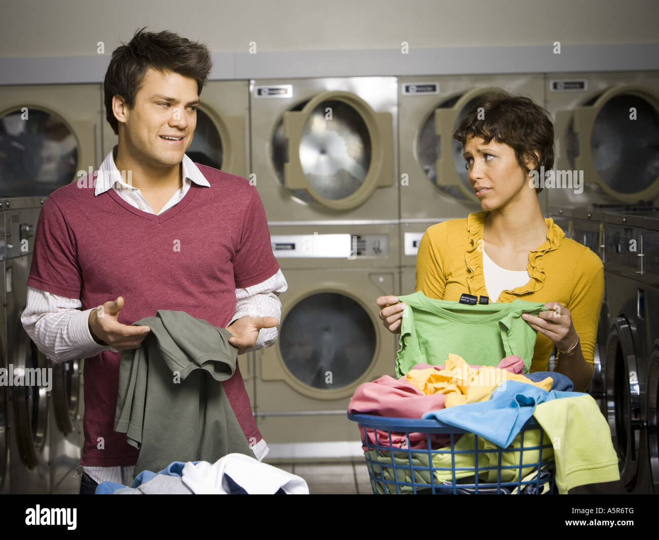 Couple folding laundry in Laundromat Stock Photo Alamy