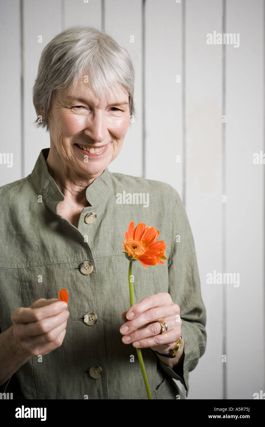 Portrait of an elderly woman holding a flower Stock Photo - Alamy