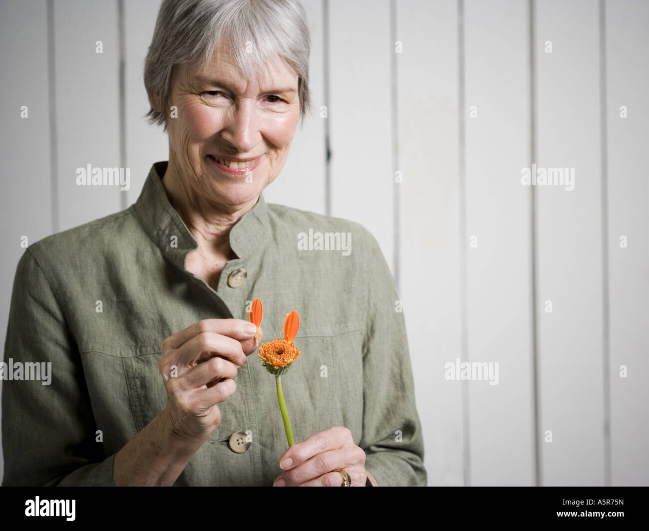 Portrait of an elderly woman holding a flower Stock Photo - Alamy