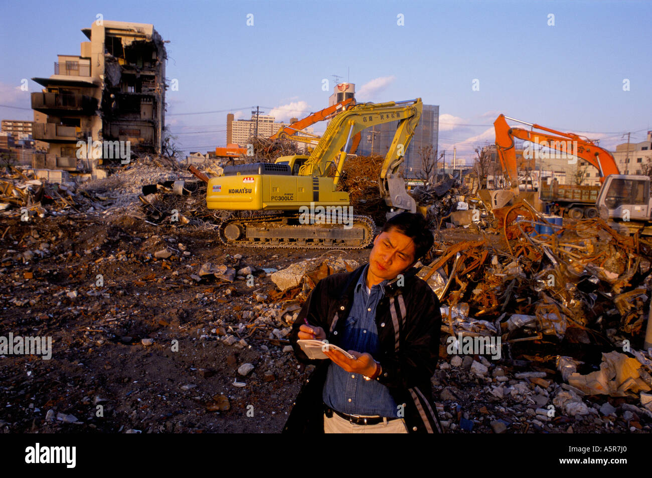 REPORTER USNG MOBILE AT SCENE OF EARTHQUAKE DISASTER KOBE JAPAN 4 1995 1995 Stock Photo