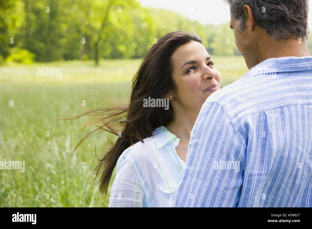 Close up of a man and a woman holding hands in a field Stock Photo - Alamy