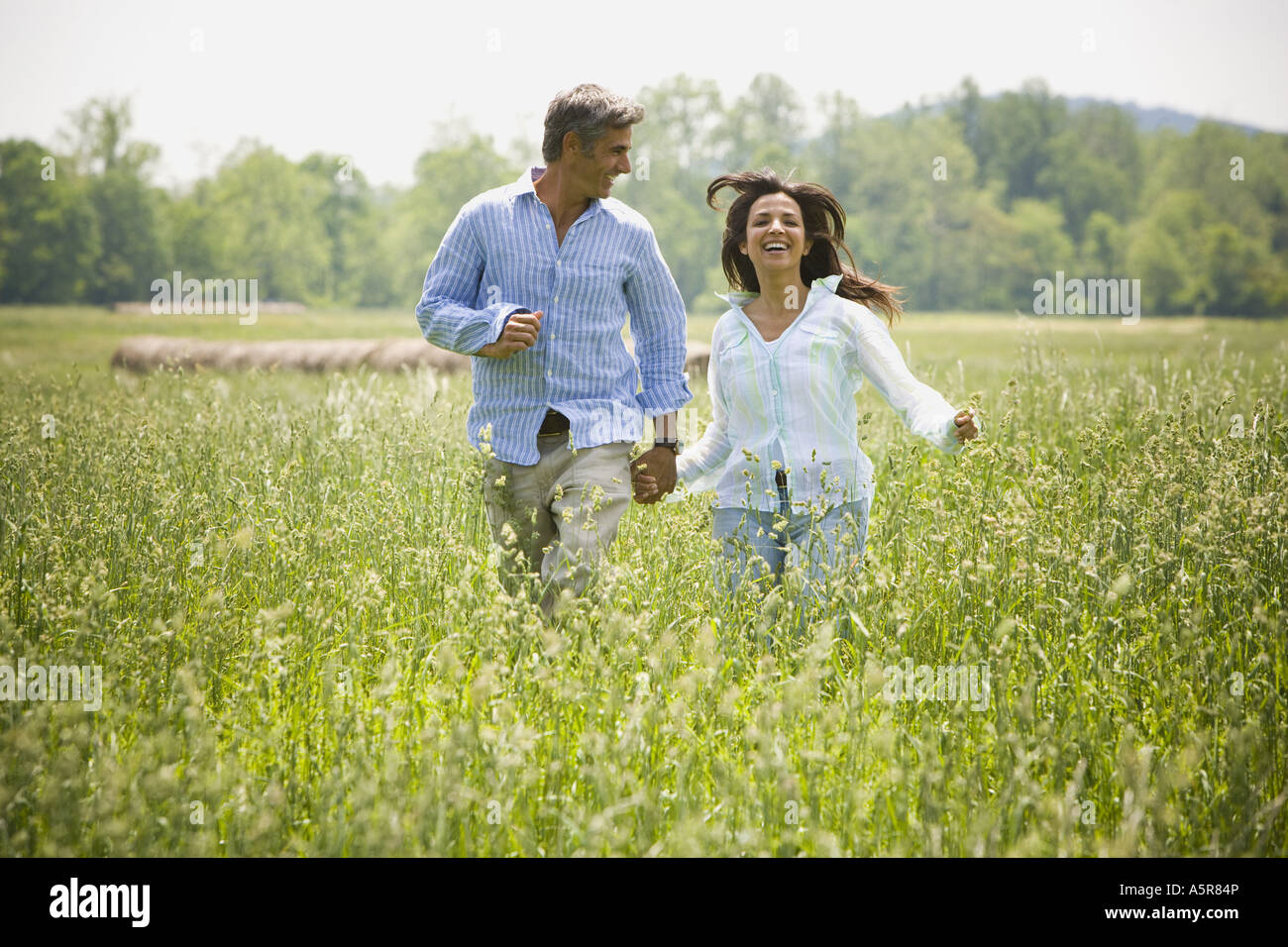 man and a woman holding hands in a field Stock Photo - Alamy