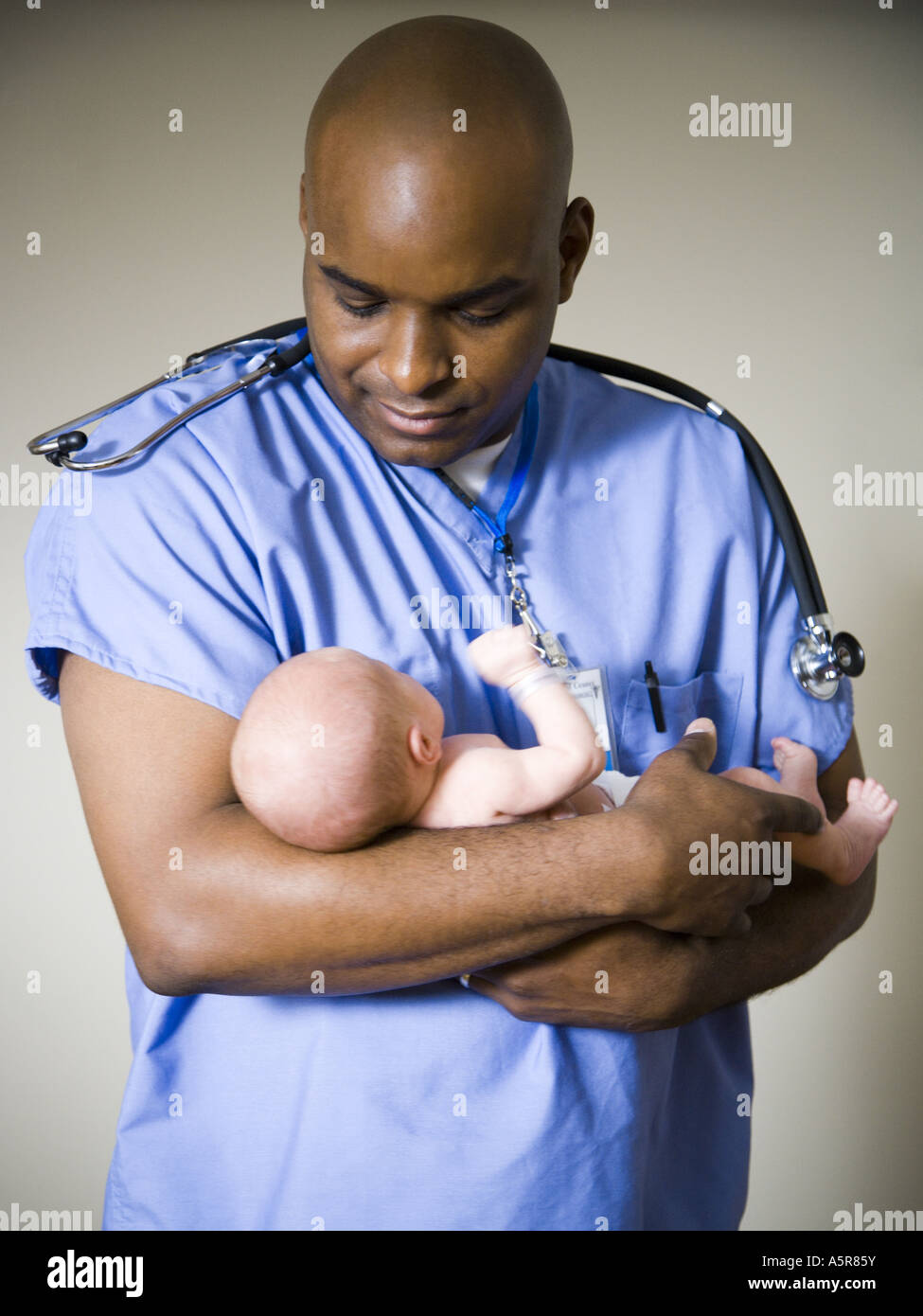 Male nurse or doctor holding newborn baby Stock Photo - Alamy