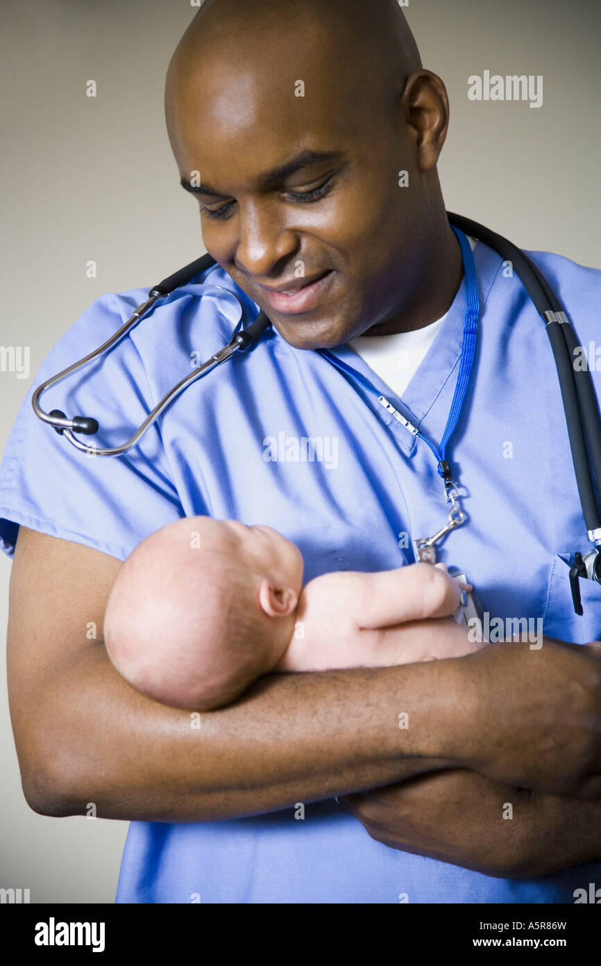 Male nurse or doctor holding newborn baby Stock Photo Alamy