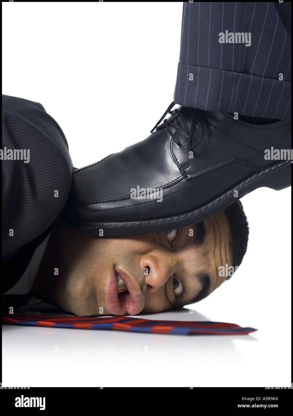 Businessman lying down being stepped on Stock Photo