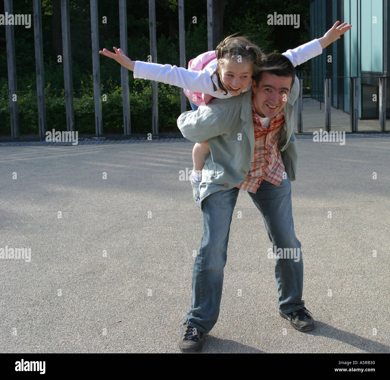 Young girl playing on her Dads shoulders Stock Photo