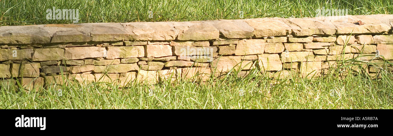 Stone rock wall landscaping fence Stock Photo - Alamy