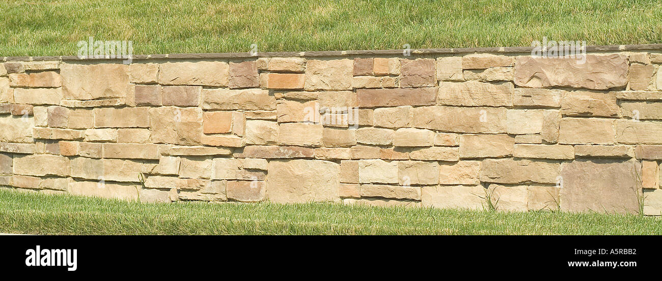Stone rock wall landscaping fence Stock Photo - Alamy
