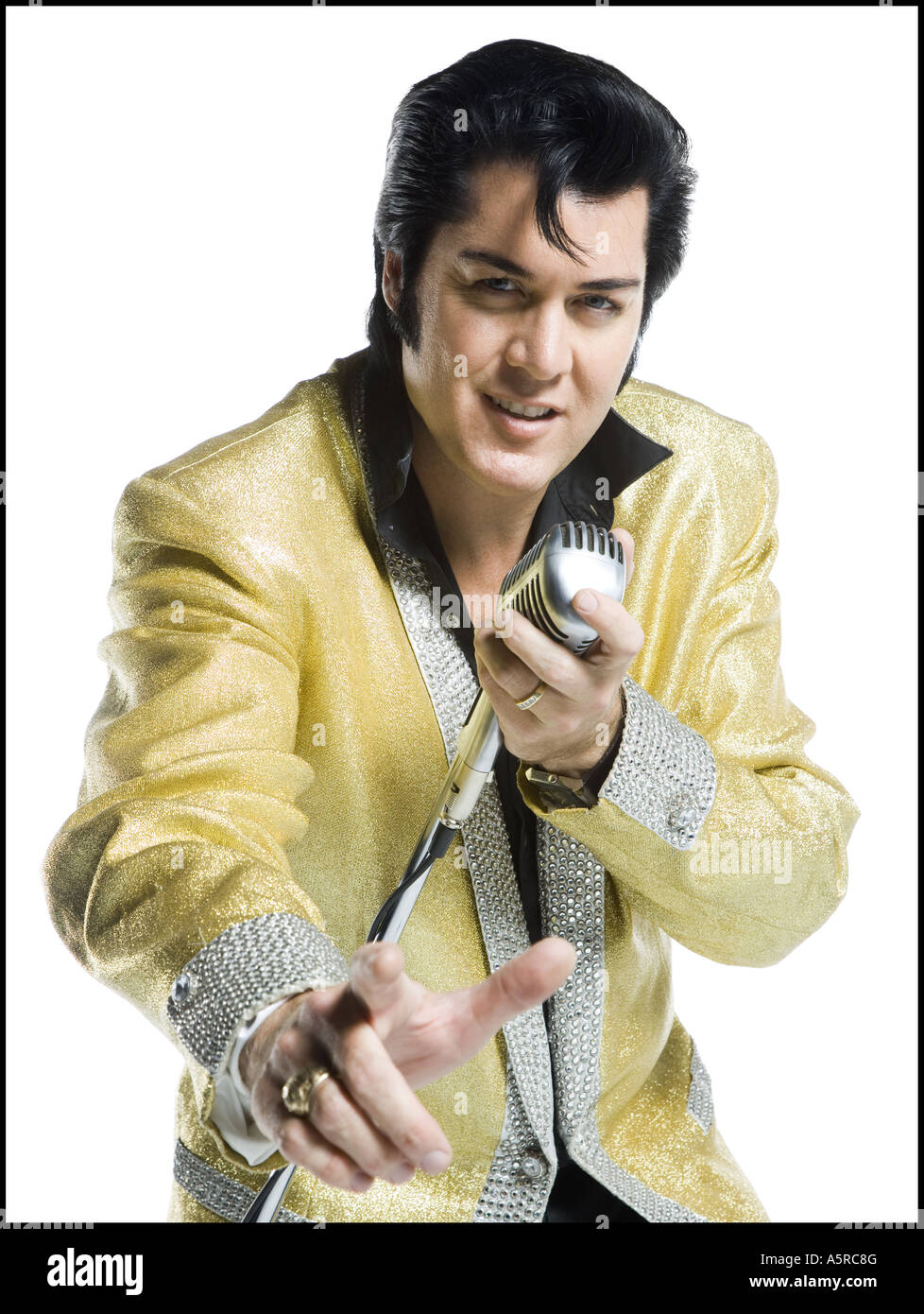 Portrait of an Elvis impersonator singing into a microphone Stock Photo