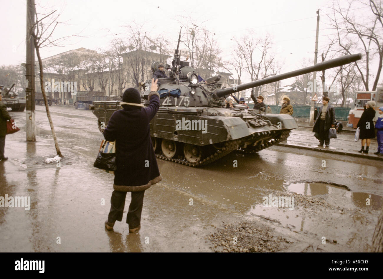 Tank Execution A WOMEN WAVES TO A MILITARY TANK AS IT DRIVES BY THE DAY AFTER ...