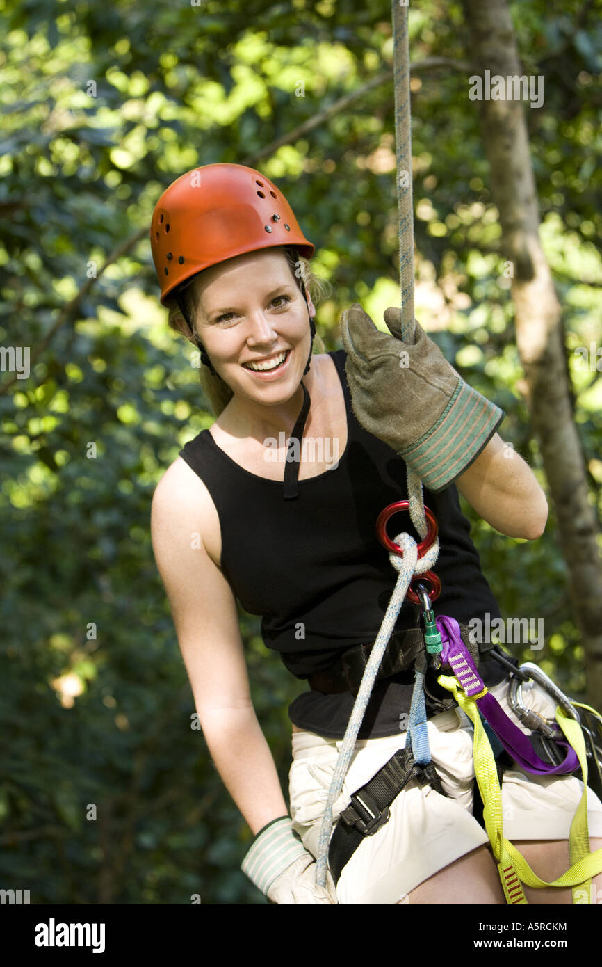 Portrait of a young woman smiling while rappelling Stock Photo - Alamy