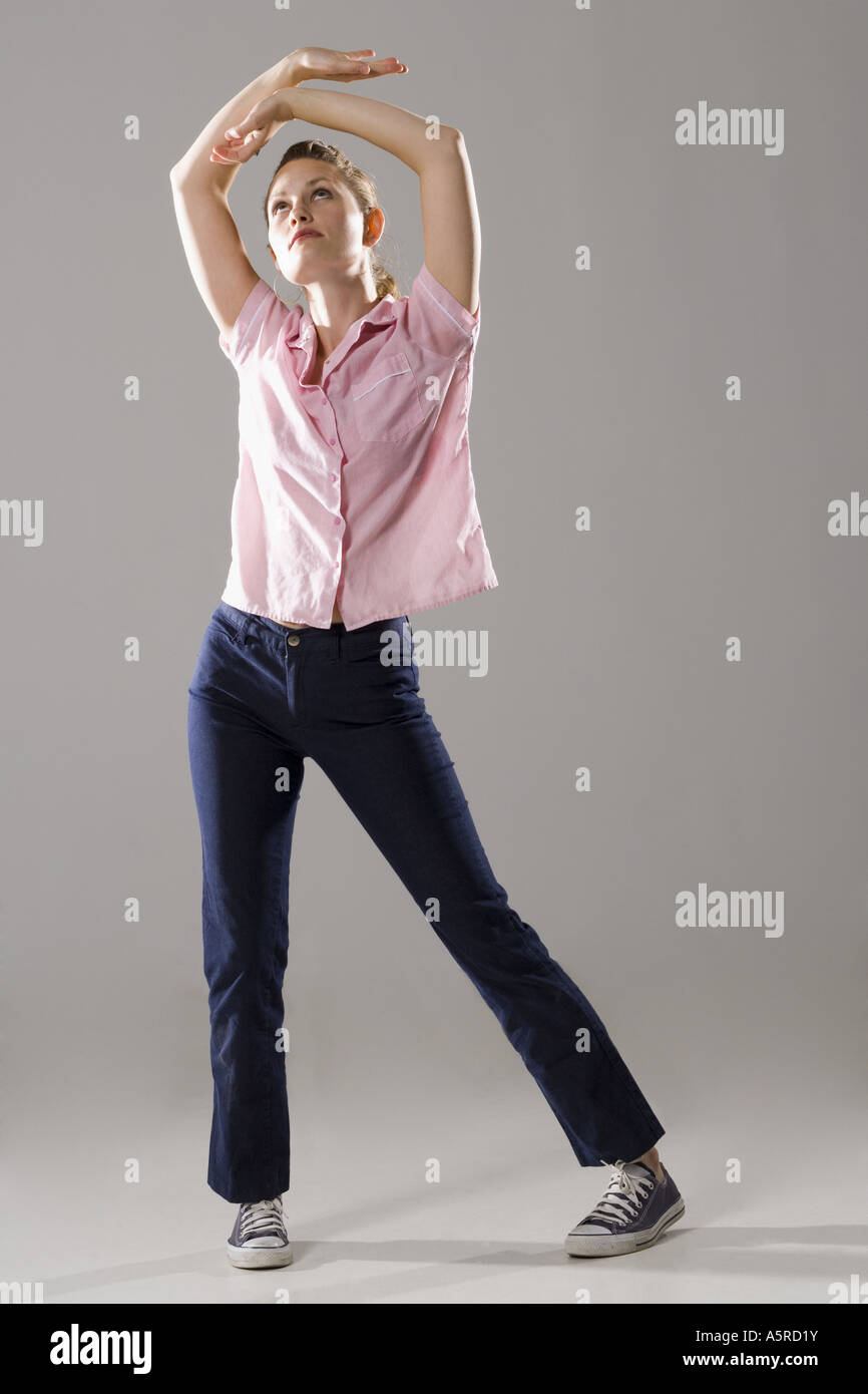 Young woman standing with her arms raised Stock Photo - Alamy