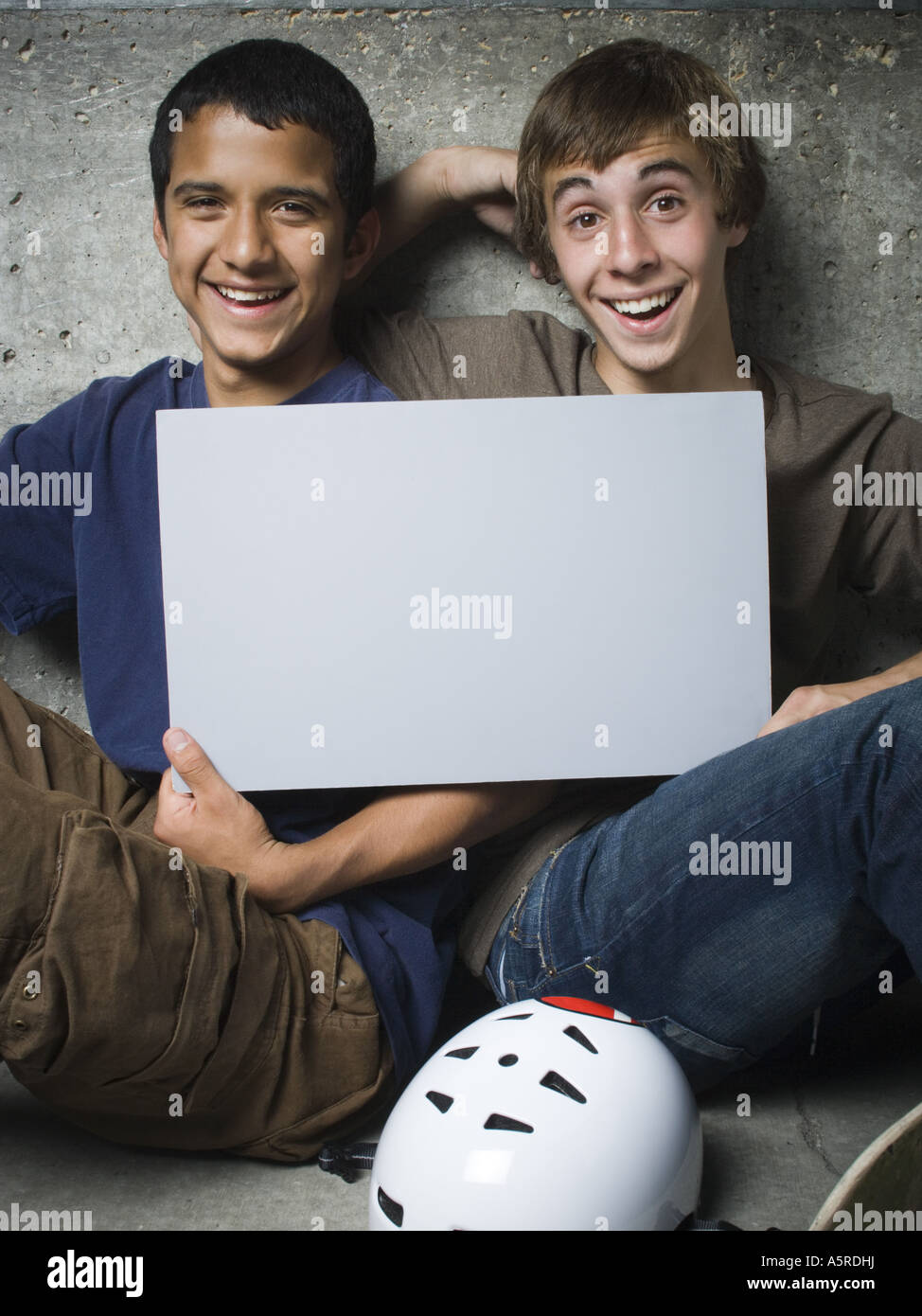 Portrait of two teenage boys holding a blank sign and smiling Stock ...